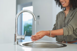 woman at a touch kitchen sink.